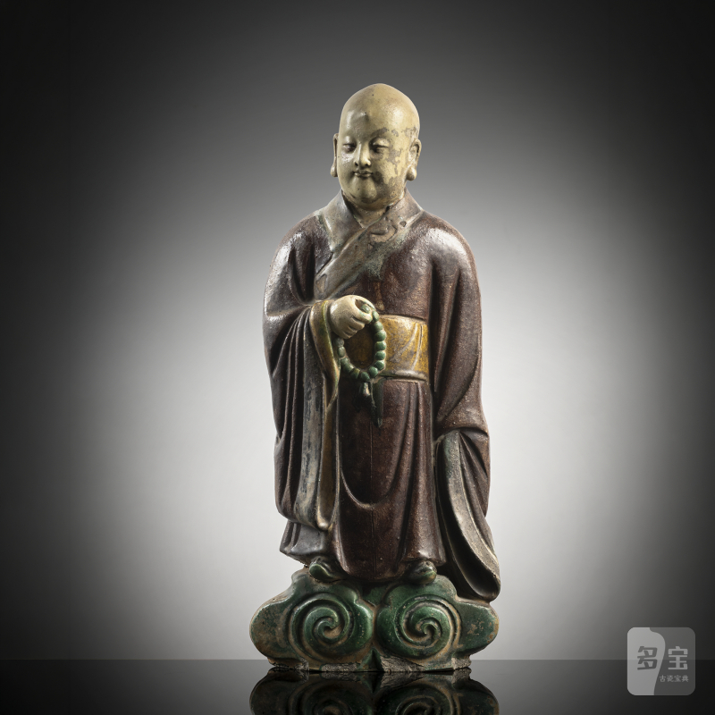 A ceramic figure of a standing monk